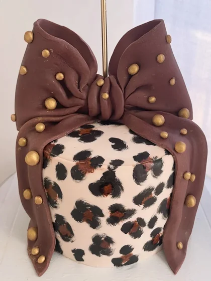 Bolo com padrão de leopardo e uma grande borboleta castanha com pormenores dourados